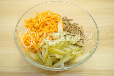 Upload соломкой нарезанные маринованные огурчики и морковь по-корейски.