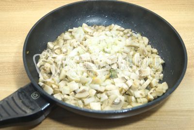 Na сковороде с растительным маслом обжарить мелко нашинкованный лук и грибы.