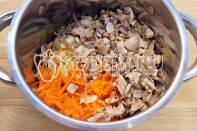 Adicionar в кастрюлю измельченную капусту, грибы и тертую морковь. Добавить 100 мл. воды и тушить на среднем огне 3-5 минут