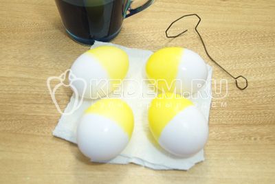 Kdy помощи держателя опустить в желтую краску на половину яйцо, хорошо просушить.