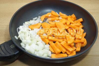 På сковороде разогреть оливковое масло и выложить кубиками нарезанный репчатый лук и крупно нарезанную морковь.