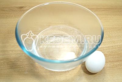 W миску с горячей водой разбить яйцо, добавить масло.