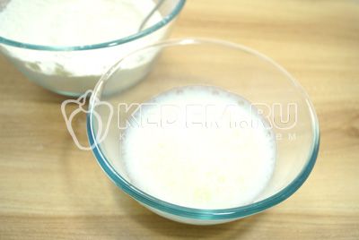 W большую миску просеять муку, добавить соль и круговыми движениями влить яйцо с водой и растительным маслом.
