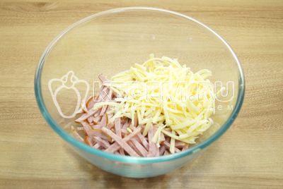 W миску нарезать соломкой колбасу, сыр натереть на терке.