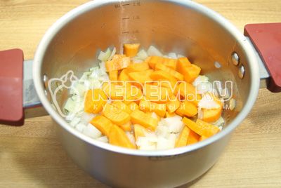 I кастрюле с толстым дном обжарить мелко нашинкованный лук и ломтиками нарезанную морковь на растительном масле.