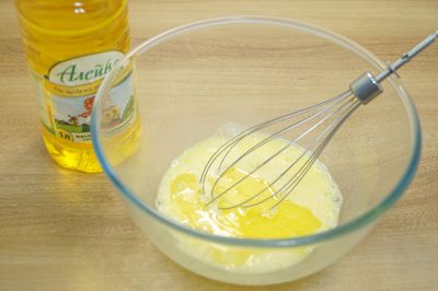 V глубокой миске взбить венчиком яйца с 2 столовыми ложками масла.