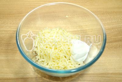 V миску натереть на мелкой терке сыр, добавить прессованный чеснок и майонез.