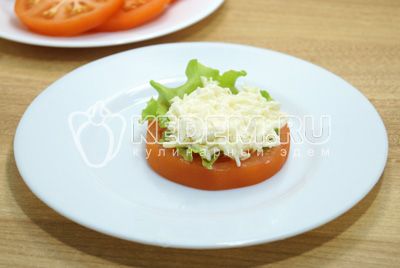 Na кружок помидоры выложить листик салата и ложку сырной начинки.